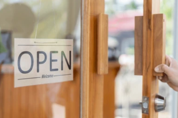 Front of a Pacific Northwest business with an open sign on the door, welcoming customers.